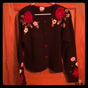 Black sweater with floral appliqués.